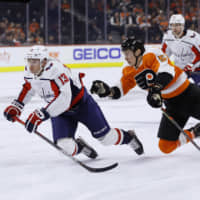 Washington\'s Jakub Vrana (left) is tripped by Philadelphia\'s Philippe Myers in the third period on Wednesday night. | AP
