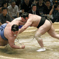 Kokkai throws down Gagamaru during their bout at the Nagoya Grand Sumo Tournament on July 11, 2010. | KYODO