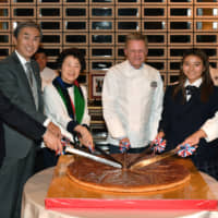 French Ambassador Laurent Pic (third from right) cuts a galette des rois, a cake traditionally served on Jan.6 to celebrate the arrival of the Three Wise Men in Bethlehem before Jesus\' birth, with (from left); Taku Otsuka, state minister of the Cabinet Office; Nobuteru Ishihara, chairman of the Japan-France Friendship Group; Eriko Yamatani, member of the House of Councillors; Shino Matsuda, Galette des Rois ambassador and future Olympic surfer; and Yukio Nishino, Galette des Rois Club president and patissier, at the French ambassador\'s residence on Jan. 16. | YOSHIAKI MIURA