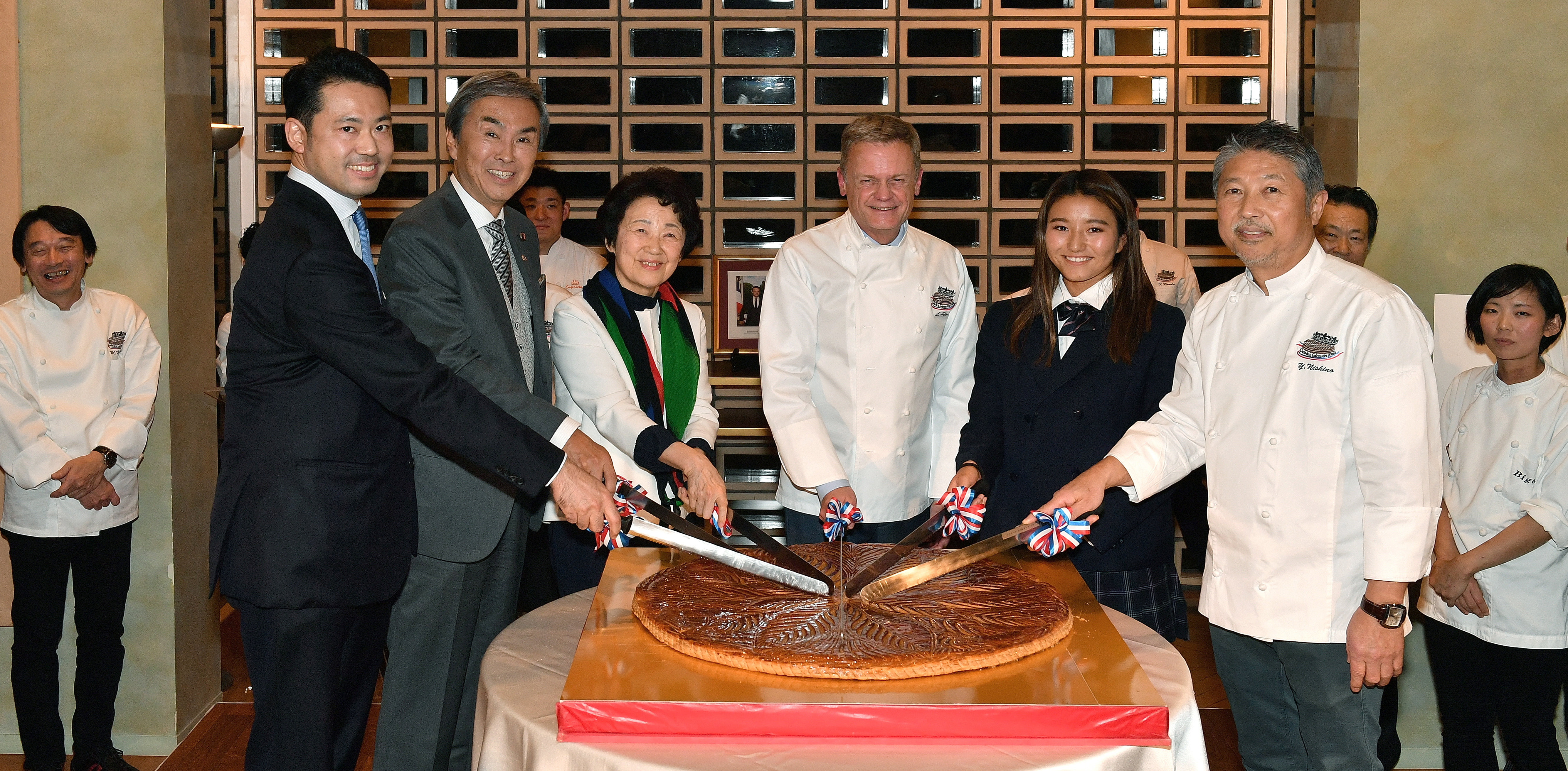 French Ambassador Laurent Pic (third from right) cuts a galette des rois, a cake traditionally served on Jan.6 to celebrate the arrival of the Three Wise Men in Bethlehem before Jesus' birth, with (from left); Taku Otsuka, state minister of the Cabinet Office; Nobuteru Ishihara, chairman of the Japan-France Friendship Group; Eriko Yamatani, member of the House of Councillors; Shino Matsuda, Galette des Rois ambassador and future Olympic surfer; and Yukio Nishino, Galette des Rois Club president and patissier, at the French ambassador's residence on Jan. 16. |   YOSHIAKI MIURA