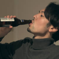 Bottoms up: Toshiyuki shares a bottle of beer with a new roommate and unknowingly shocks the panelists on \"Terrace House Tokyo 2019-2020.\" | © FUJI TELEVISION / EAST ENTERTAINMENT
