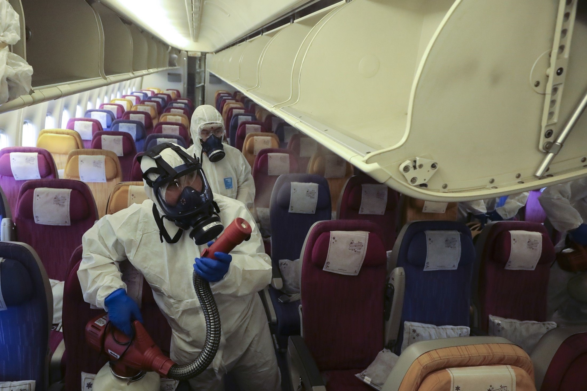 Disinfectant is sprayed on an airplane by staff in hazmat suits. | PHOTOGRAPHER: PATIPAT JANTHONG/B