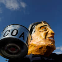 An activist wearing a mask depicting Japan\'s Prime Minister Shinzo Abe takes part in a protest to demand Japan stop supporting coal, outside the venue of the U.N. climate change conference (COP25) in Madrid in December. | REUTERS