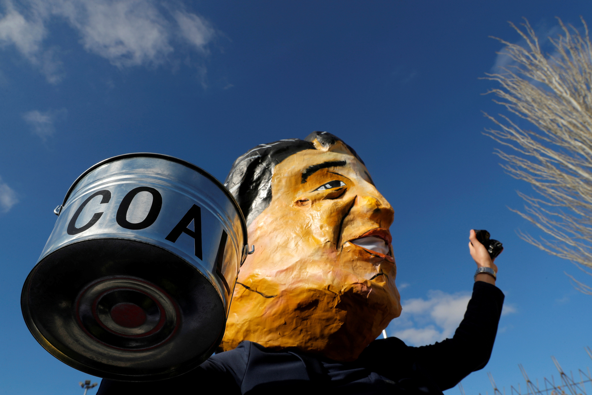 An activist wearing a mask depicting Japan's Prime Minister Shinzo Abe takes part in a protest to demand Japan stop supporting coal, outside the venue of the U.N. climate change conference (COP25) in Madrid in December. | REUTERS