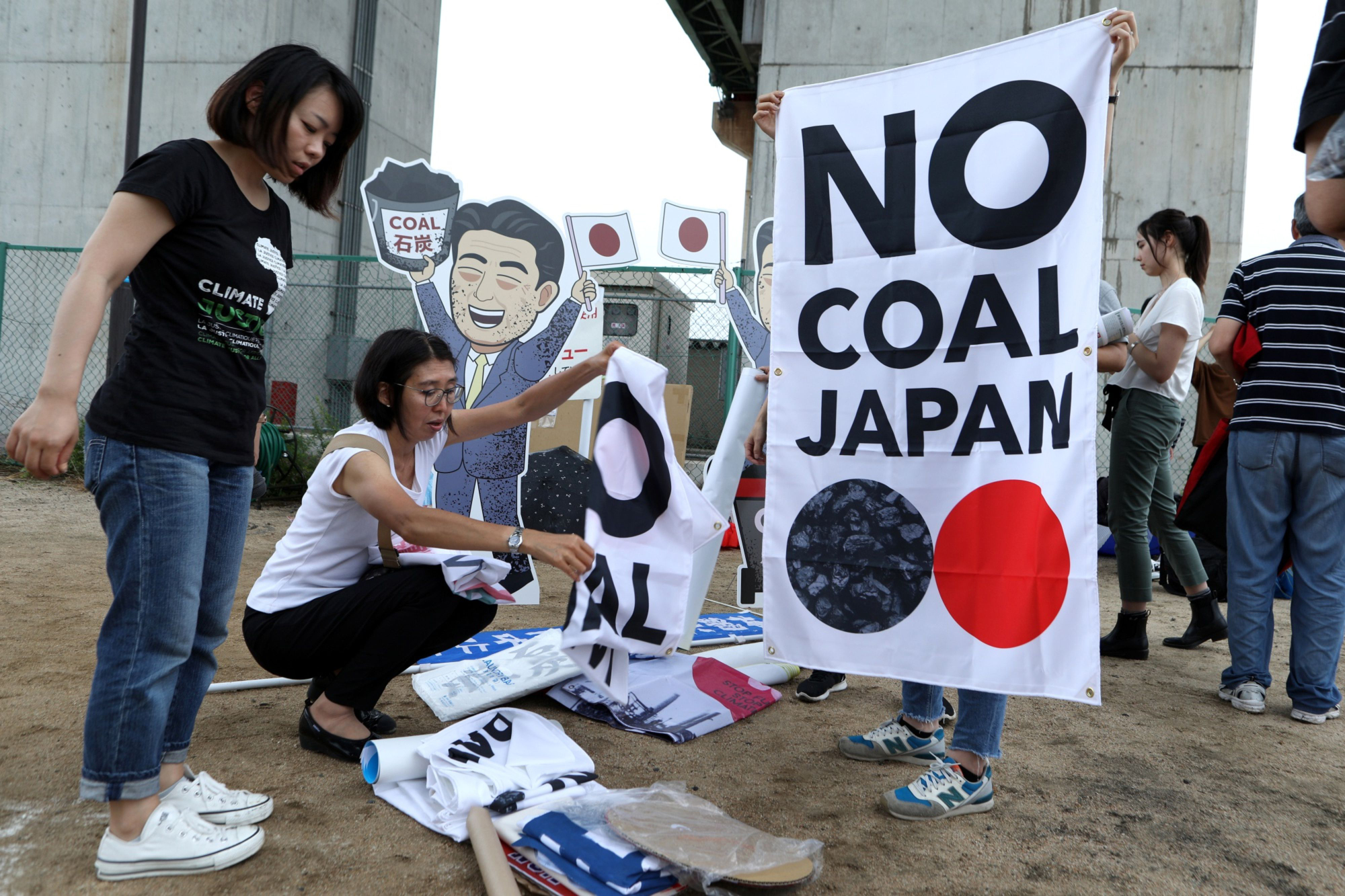 Protesters in Kobe prepare banners prior to a rally in June against Japan's support for new coal-fired power generation projects. | BLOOMBERG