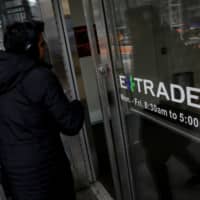 A man enters the building housing E*Trade Financial Corp.\'s offices in New York on Thursday. | REUTERS
