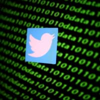 The Twitter logo and binary cyber codes are seen in this illustration taken in November. | REUTERS