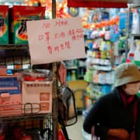 A sign announces that masks are sold out at a grocery store following the outbreak of a new coronavirus, in Hong Kong Sunday. | REUTERS