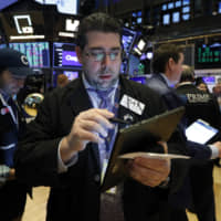 Trader Michael Capolino works on the floor of the New York Stock Exchange Thursday,. U.S. stocks rose in midday trading Thursday as investors continued focusing on the latest round of corporate earnings and China cut tariffs on key imports as part of a trade war truce. | AP