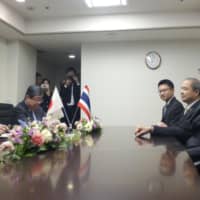 Economy minister Yasutoshi Nishimura (left) holds talks Monday in Tokyo with Thai Deputy Prime Minister Somkid Jatusripitak on the Trans-Pacific Partnership. | ?¯