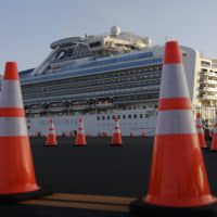 A security guard stands near the quarantined Diamond Princess cruise ship in Yokohama on Feb. 13. | AP