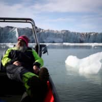 International director of the Norwegian Polar Institute, Kim Holmen, relaxes with tea as he travels past the Wahlenberg Glacier in Oscar II land at Spitsbergen in Svalbard, Norway, last August. | REUTERS