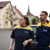 Kristin and Thomas Schmitt, employees of the Bamberg branch of the French tire manufacturer Michelin, leave their house in Baunach on Feb. 13.  | REUTERS
