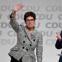 Annegret Kramp-Karrenbauer waves next to German Chancellor Angela Merkel in 2018. | REUTERS