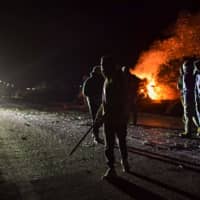 Demonstrators clash with Greek riot policemen, as they protest the construction of a new controversial migrant camp, near the town of Mantamados on the northeastern Aegean island of Lesbos Tuesday. | AFP-JIJI