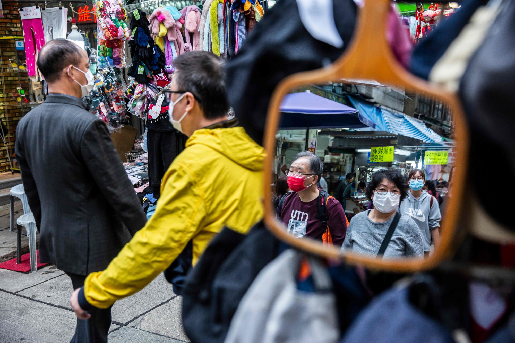 People wearing protective face masks walk through a market in Hong Kong on Tuesday. | AFP-JIJI