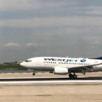 A Westjet plane lands at La Guardia International Airport in New York in 2018. A passenger jet taking winter-weary Canadians to Jamaica was forced to turn back after a passenger falsely claimed to have the coronavirus, the airline said Tuesday. The Westjet flight to Montego Bay was diverted to Toronto on Monday \"due to an unruly guest,\" spokesman Morgan Bell told AFP. | AFP-JIJI