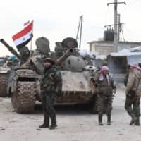 Syrian government forces deploy near the Damascus-Aleppo highway in the southern part of Syria\'s northern Aleppo province on Monday. Syrian regime artillery killed five Turkish soldiers in Idlib Monday, Turkey\'s defense ministry said, as the number of people displaced by violence in the region neared 700,000 since December. | AFP-JIJI