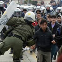 Riot police scuffle with migrants during a protest in Mytilene port on the northeastern Aegean island of Lesbos, Greece, on Tuesday. Asylum seekers have demonstrated for a second day on Lesbos amid rising tension, protesting increasingly dire living conditions in and around the island\'s massively overcrowded migrant camp and delays in Greece\'s asylum process. | MANOLIS LAGOUTARIS / INTIME NEWS / VIA AP
