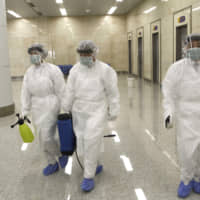 State Commission of Quality Management staff armed with protective gear and disinfectant prepare to check the health of travelers arriving from abroad at the Pyongyang Airport in Pyongyang Saturday. | AP