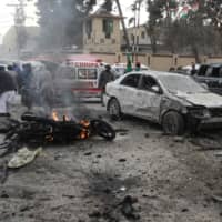 A motorbike is seen in flames next to damaged vehicles after a suicide blast in Quetta, Pakistan, on Monday. | AFP-JIJI