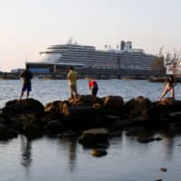 The MS Westerdam cruise ship is moored Thursday in Sihanoukville, Cambodia, where it has been granted permission to dock following nearly two weeks at sea after being turned away by five countries over coronavirus fears. | REUTERS