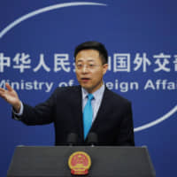 Chinese Foreign Ministry spokesman Zhao Lijian gestures as he speaks during a daily briefing at the Ministry of Foreign Affairs office in Beijing Monday. China\'s foreign ministry on Monday said it didn\'t matter that three expelled journalists had nothing to do with a Wall Street Journal editorial that Beijing deemed racist, and called on the paper to apologize. | AP