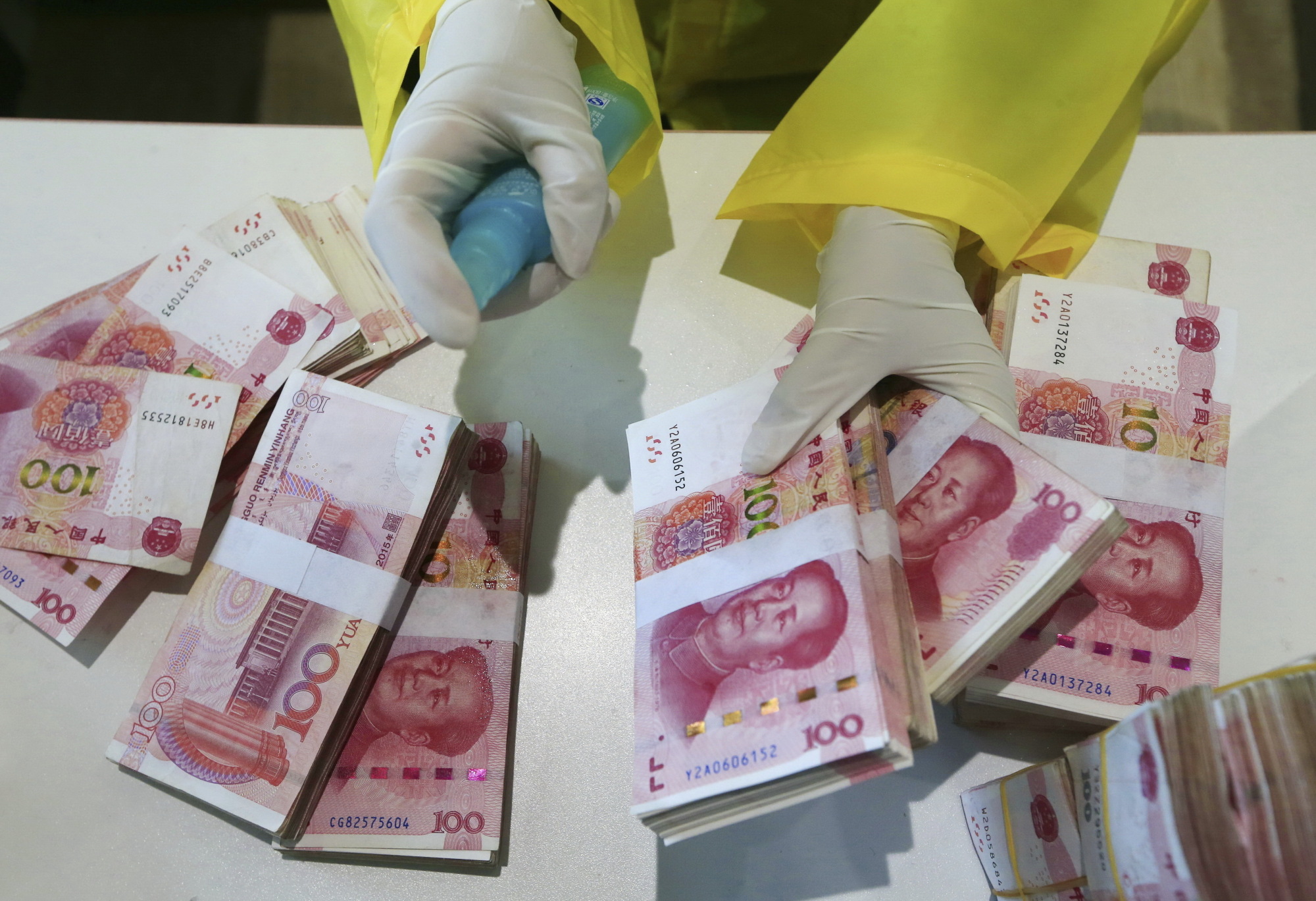 Bank notes are disinfected in the headquarters of the Suining Bank in Suining, in southwest China's Sichuan province, on Wednesday after China's central bank ordered banks to put money through a quarantine period or disinfect it and to destroy cash from places like hospitals and public transport services to curb the spread of the new coronavirus. | CHINATOPIX / VIA AP