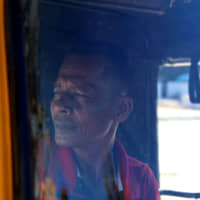 Sihanoukville tuk-tuk driver Kwan Samhay waits for customers. | REUTERS