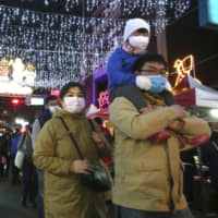 People in Taiwan wear protective face masks as they view lanterns on display for the Lunar New Year in Taipei on Feb. 9. | AP