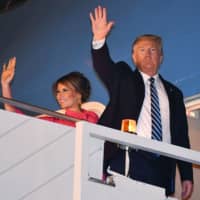 U..S President Donald Trump and first lady Melania Trump wave as they board Air Force One at Palam Air Force Airport in New Delhi on Tuesday. | AFP-JIJI