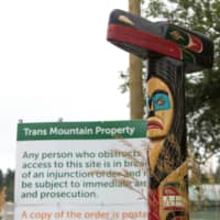 A totem pole outside the Kinder Morgan Burnaby Terminal and Tank Farm in Burnaby, British Columbia, on June 20. | AFP-JIJI