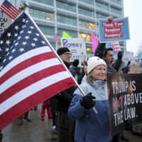 Residents of Utah gather at the Wallace F. Bennett Federal Building in Salt Lake City on Wednesday to thank Sen. Mitt Romney for his vote to convict U.S. President Donald Trump. | AP