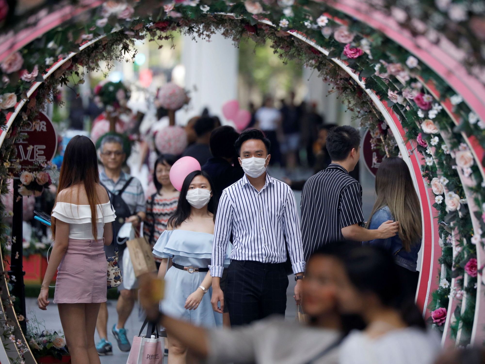 A masked couple celebrate Valentine's Day at Orchard Road in Singapore on Friday. | REUTERS