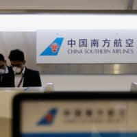 Employees of China Southern Airlines wear surgical mask as a preventive measure in light of the coronavirus outbreak in China, as they wait for customers behind the counter at Benito Juarez International Airport in Mexico City on Tuesday. | REUTERS