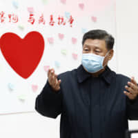 Chinese leader Xi Jinping gestures near a sign that says \"Race against time, Fight the Virus\" during an inspection of the center for disease control and prevention of Chaoyang District in Beijing on Feb. 10. | XINHUA / VIA AP