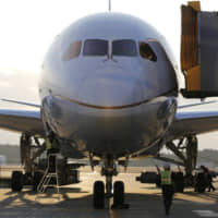 Ground staff at Narita Airport work under a United Airlines Boeing 787 Dreamliner just in from Los Angeles. | REUTERS