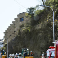 Rescuers on the scene of a landslide that killed an 18-year-old woman on Wednesday | KYODO