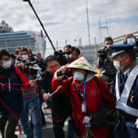 A passenger leaves a port in Yokohama on Wednesday after disembarking the Diamond Princess cruise ship. | AFP-JIJI