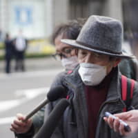 An man in his 70s speaks to the media outside Yokohama Station on Wednesday shortly after disembarking from the Diamond Princess, a cruise ship that had been quarantined in Yokohama for two weeks. | RYUSEI TAKAHASHI.