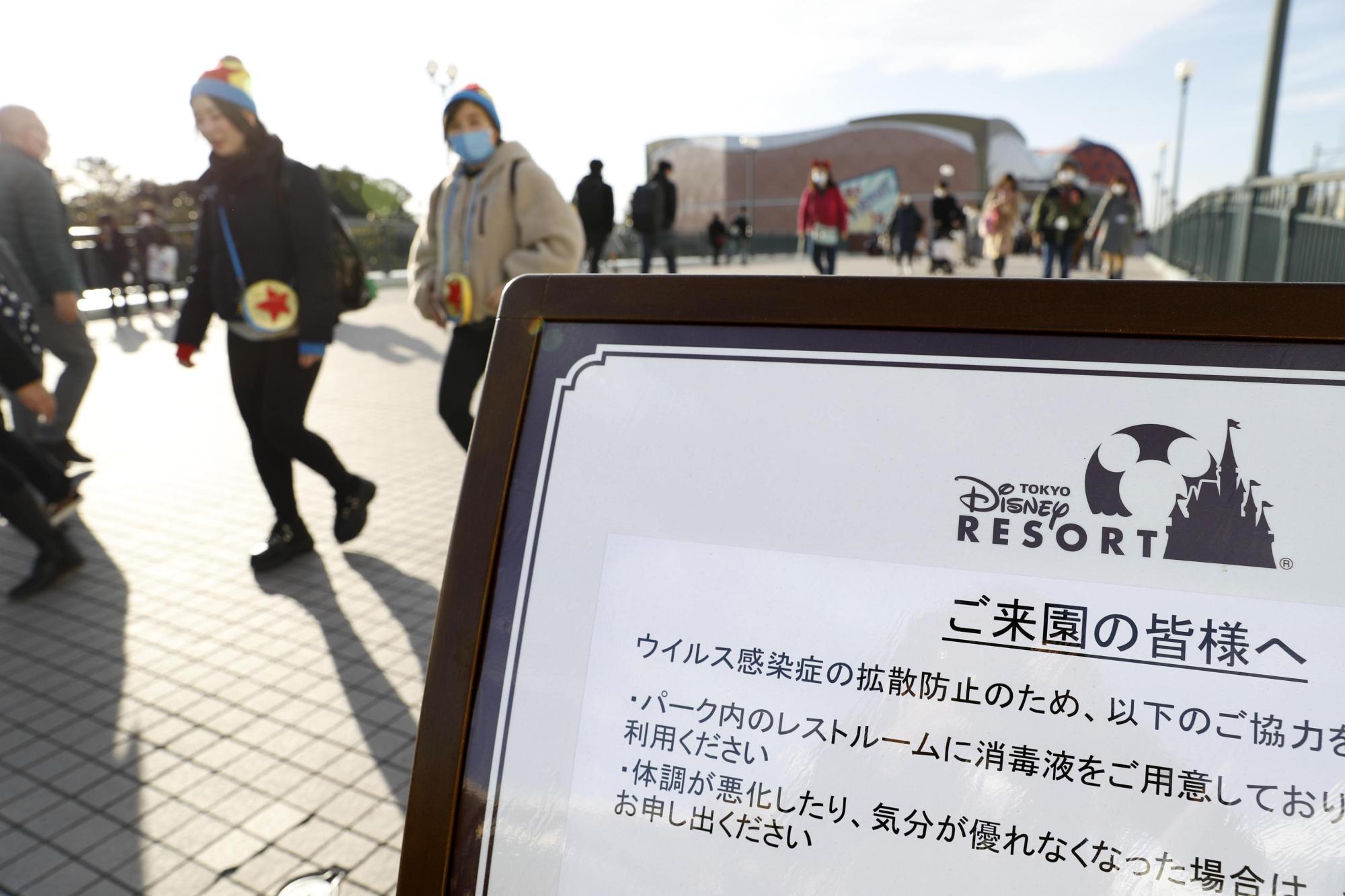 A sign is put up near a train station close to Tokyo Disneyland asking visitors to use hand sanitizer in a photo taken on Feb. 3. The theme park will be closed from Saturday amid the outbreak of COVID-19 infections. | KYODO