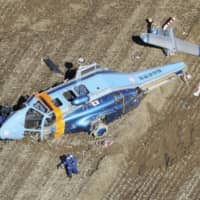 A Fukushima Prefectural Police helicopter lies in a field after crashing in the city of Koriyama on Saturday. | KYODO