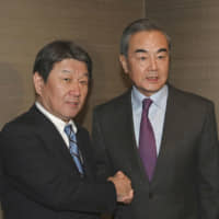 Foreign Minister Toshimitsu Motegi (left) and Chinese State Councilor Wang Yi meet in Munich in February. | FOREIGN MINISTRY / VIA KYODO