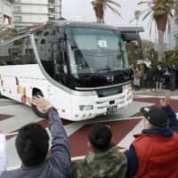 People see off a bus carrying evacuees from Wuhan, the epicenter of the new coronavirus outbreak in China, as it leaves a hotel in Katsuura, Chiba Prefecture, near Tokyo, on Thursday. | KYODO