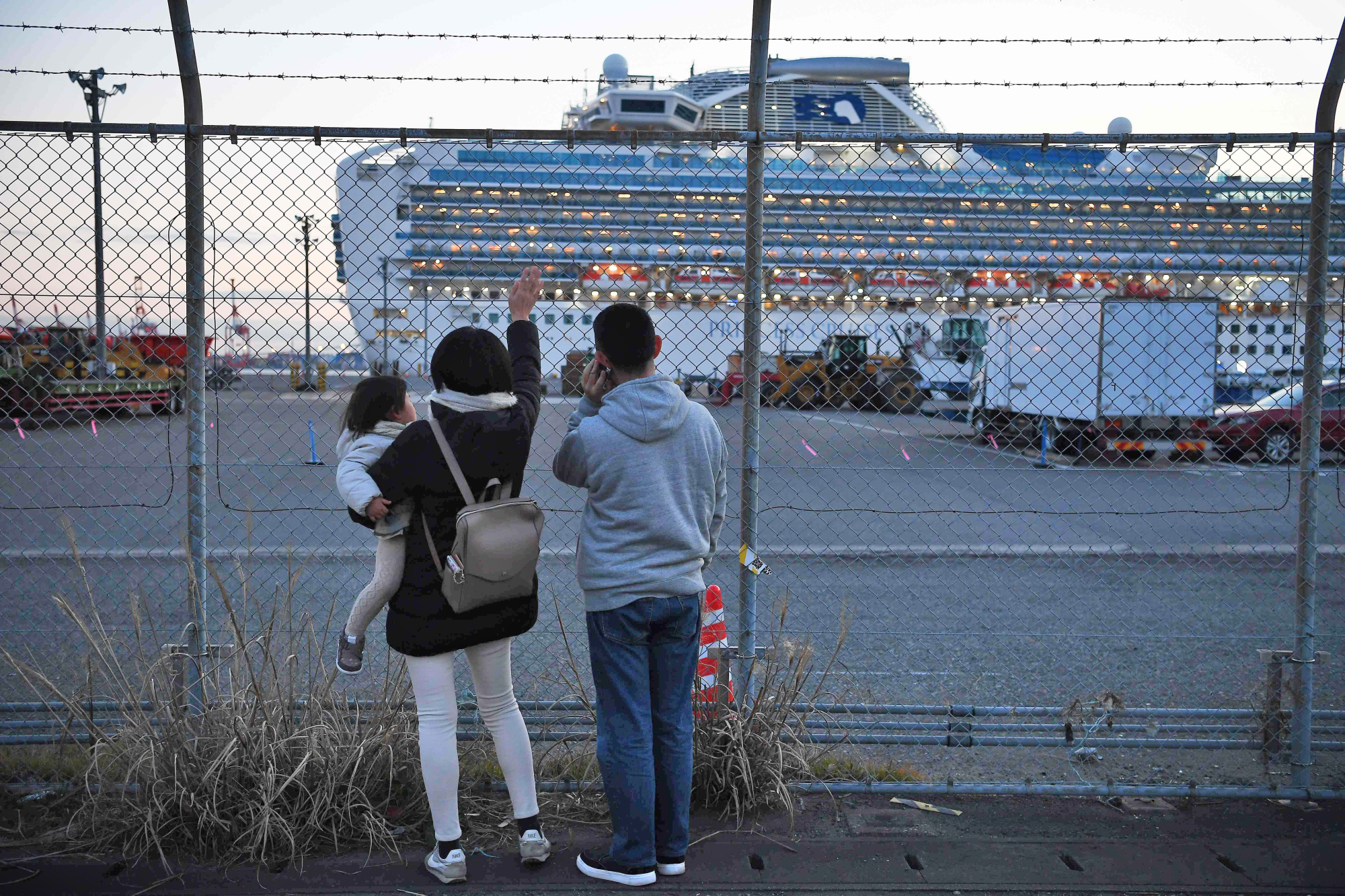 Relatives of passengers wave towards the Diamond Princess cruise ship, with around 3,600 people quarantined onboard due to fears of the new coronavirus. | AFP-JIJI