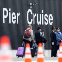 Passengers leave the Diamond Princess at Daikoku Pier Cruise Terminal in Yokohama on Saturday. | REUTERS