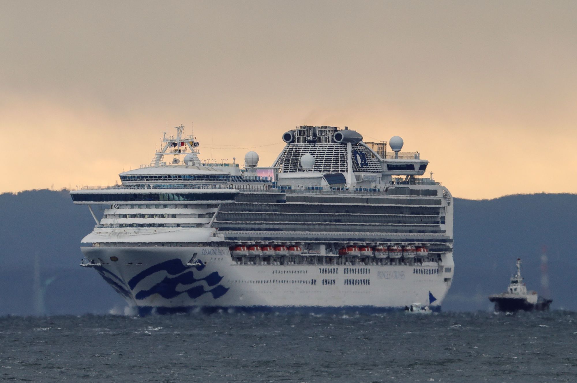 The cruise ship Diamond Princess approaches Yokohama port Thursday morning. Ten more people on the ship have tested positive for the coronavirus. | REUTERS