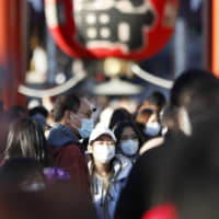 Tourists wear masks in the Asakusa district of Tokyo on Saturday amid the spread of the new coronavirus. | KYODO