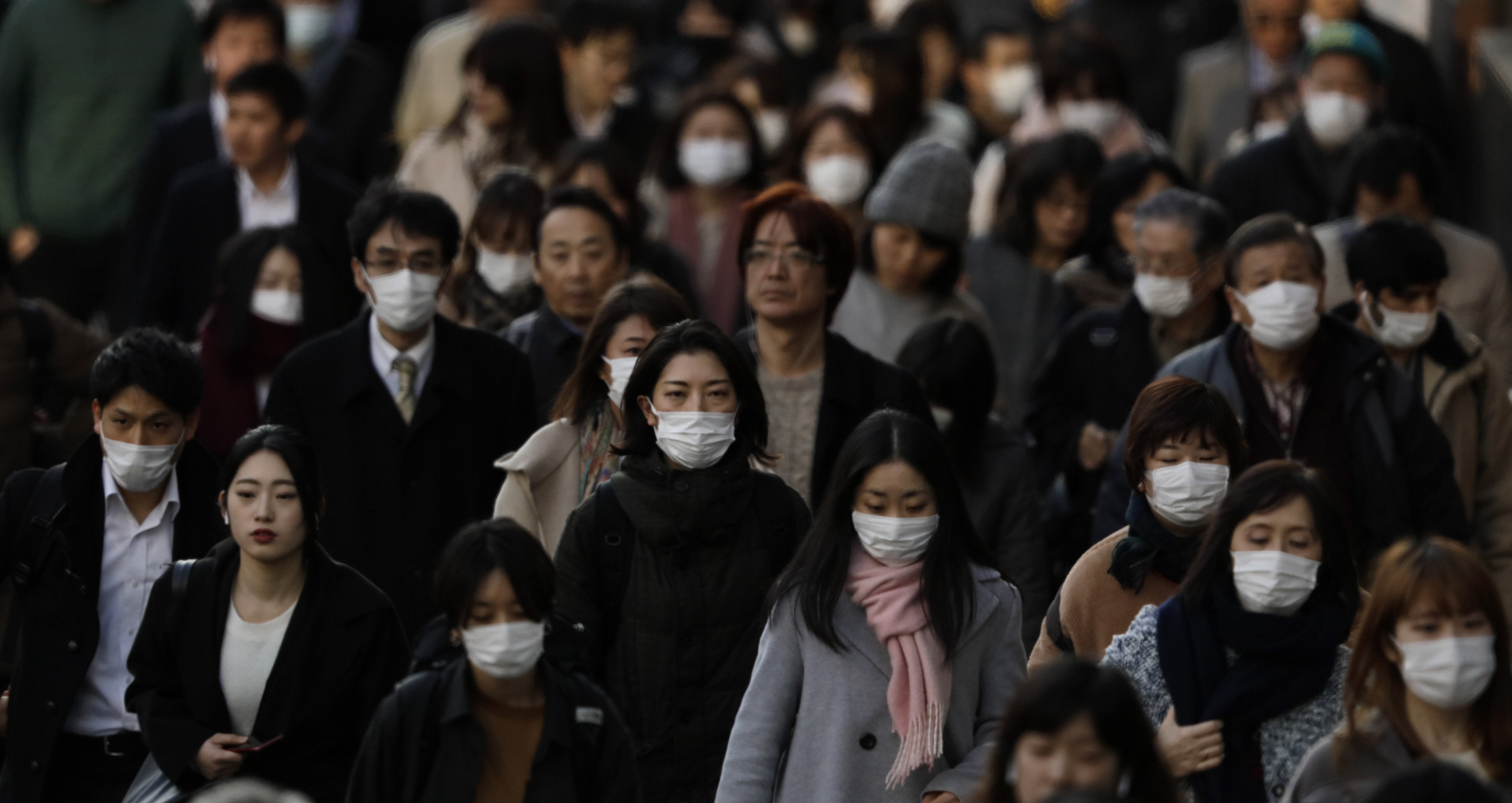 Increasingly, commuters are wearing face masks in Tokyo. On Monday, the government released guidelines for people who fear they have been infected with COVID-19. | AP