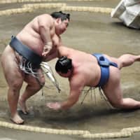 Pushed to the edge: Tokushoryu (left) defeats Shodai on the 14th day of the New Year Grand Sumo Tournament at Ryogoku Kokugikan in Tokyo on Jan. 25. | KYODO